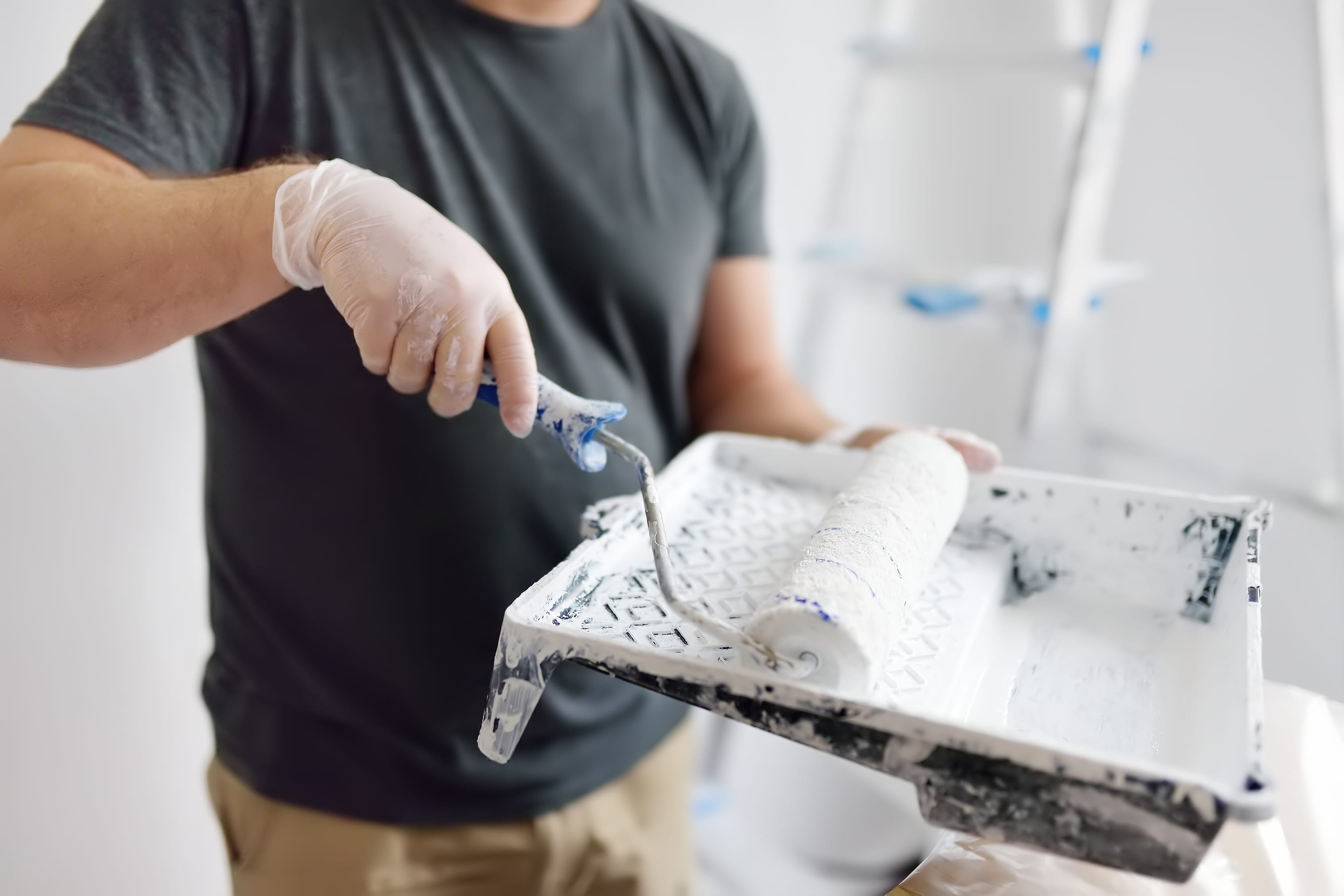 Painter refilling roller with premium interior paint