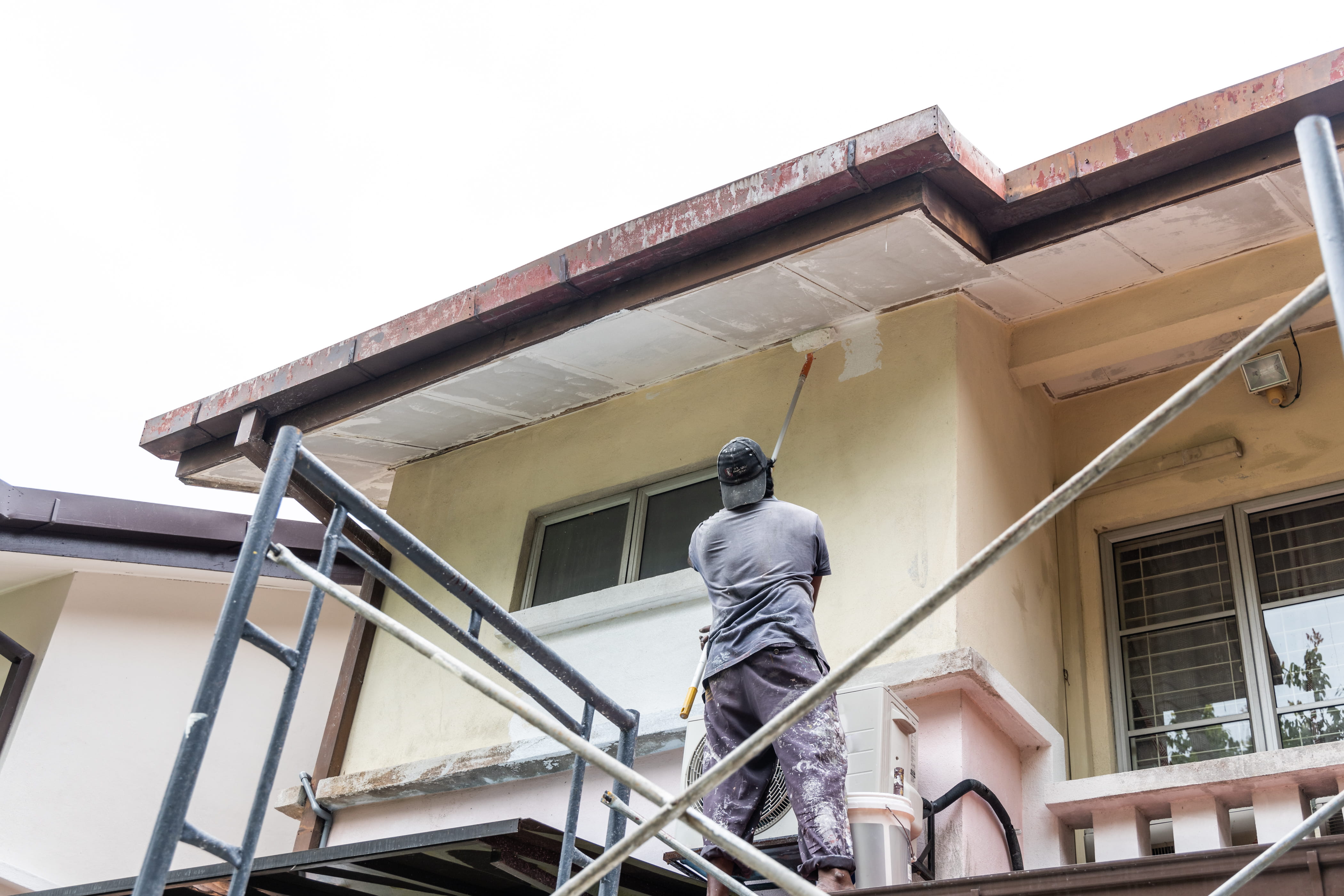Painter applying protective roof coating